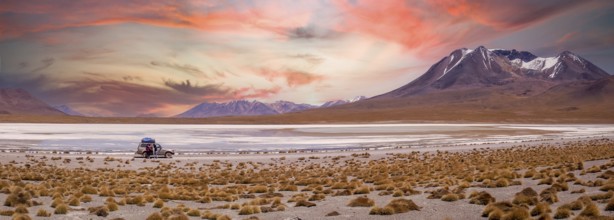 Amazing sky at sunset over Altiplano, Bolivia as an off-road vehicle is driving by