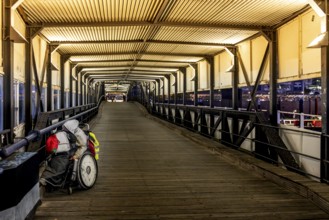 Homeless man in wheelchair in Überseebrücke, evening light, harbour, Hamburg, Germany, Europe