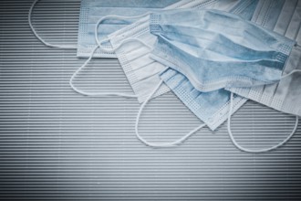 Horizontal image of disposable face masks on a striped background