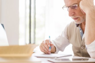 Senior professor glasses writing notebook classroom