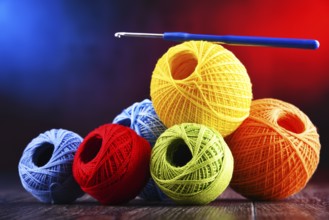 Composition with assortment of different colored yarns and hook for crocheting