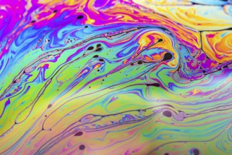 Abstract background made from soap bubble reflecting light. Rainbow soap bubble on a dark