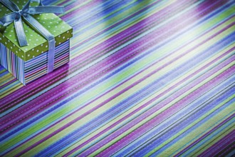 Cardboard box with ribbon on striped tablecloth celebration concept