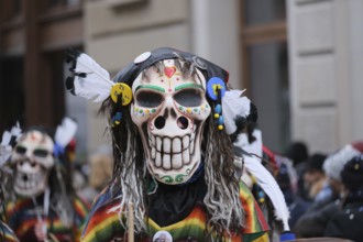 Colourful skull masks with decorative feathers in an exuberant parade