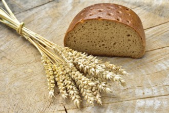 Cereal, wheat and bread on a wooden table. Different types of bread on wood