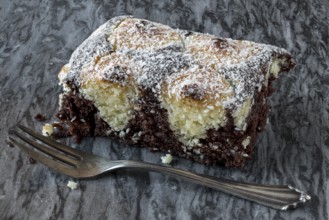 Coconut cake on a marble plate with silver fork