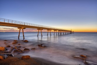 The Badalona pier, known as Pont del Petroli, in front of sunrise
