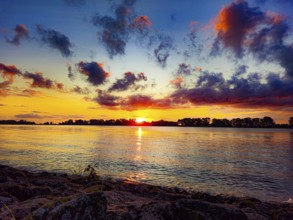 Intense sunrise with vivid colours, dramatic clouds over the water, Weserstrand 26931