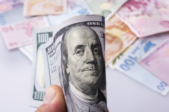 American dollar banknotes and Turksh Lira banknotes side by side on white background