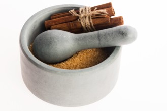 Cinnamon sticks with pure cane brown sugar in mortar