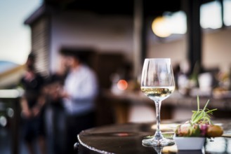 Glass of white wine with gourmet food tapa snacks in outdoors bar at sunset