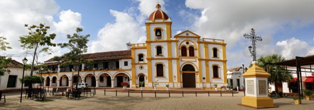 Typical street with white historic buildings in sun and shadow of Santa Cruz de Mompox, Colombia,