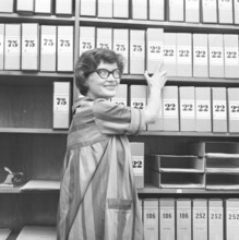 1950s glasses. A young woman in glasses and bows August 1959 is working in an archive