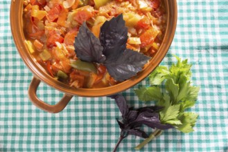 Closeup of delicious stew with mixed vegetables, arranged with green and purple leaves