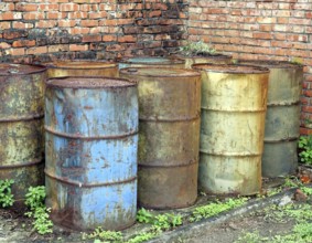 Corroding oil drums in a deserted building pollute the ground
