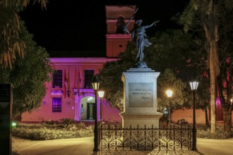 Colorful illuminated church and a statue in foreground on Freedom Square, Santa Cruz de Mompox,