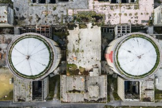 Aerial view from drone of abandoned and ruined Nuclear Power Plant or station, round tower of