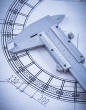 Close up of metal trammel caliper on blueprint construction concept
