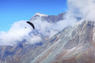 Paraglider over mountain snow peaks, Swiss Alps, Zermatt, Switzerland, Europe