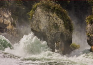 Wild water rages around the rocky island in the Rhine Falls near Schaffhausen