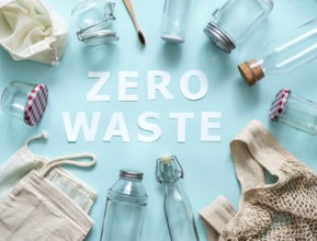 Zero waste concept. Textile eco bags, glass jars and bamboo toothbrush on blue background with Zero