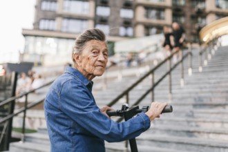 Active old woman riding electric scooter. Retired lady uses environmentally friendly city vehicle.