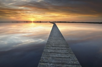 Long walkway on big lake at serene sunset