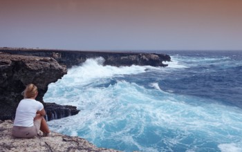 Woman watching storm on the coast, Netherlands Antilles, Bonaire, Caribbean, Caribbean Sea,