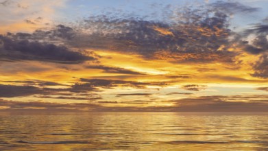 An image of a sunset sky at the ocean background