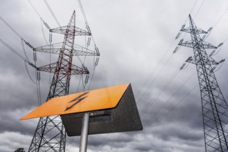 The pylon of a high-voltage power line in front of dark clouds. Austria