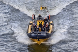 Speedboat with several people travelling at high speed across the water, London, London region,