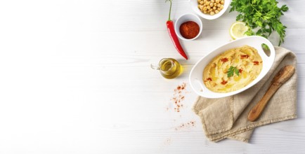 Hummus paste with lemon and chilli on a white background