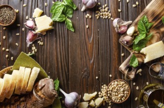 Flat lay view at food background of genovese pesto sauce ingredients on wooden kitchen table with