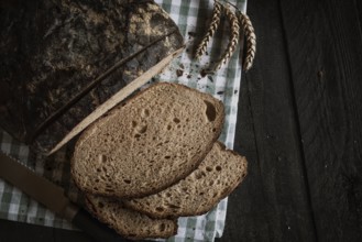 Brown homemade bread on a rustic table. Flat lay image with sliced bread on a kitchen towel