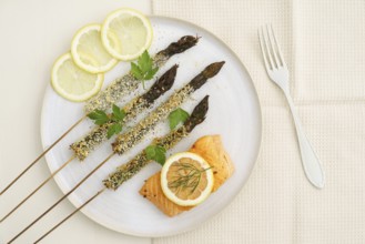 Panko-fried green asparagus on a skewer with salmon and lemon