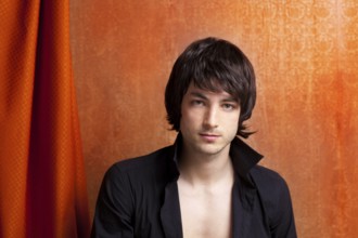 British indie pop rock look young man on orange brown retro background