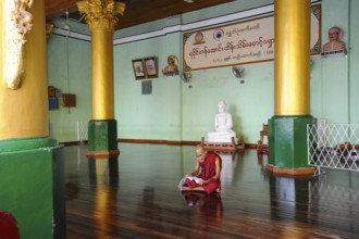 10.08.2013, Yangon, Myanmar, Asia, A Buddhist monk sits on the floor in the temple area of the