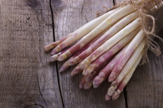 Bunch of fresh white asparagus on old wooden board