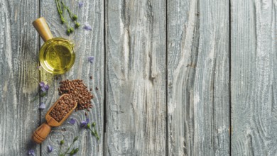 Flax seeds and flax oil. Brown linen seeds and flaxseed oil on old gray wooden background. Copy