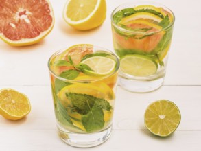 Cold homemade lemonade with fresh lemon, lime, grapefruit and mint. Summer drink on white wooden