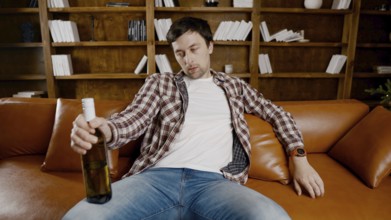 Alcohol addiction at young age. Caucasian male cannot stop drinking alcohol, drunken lonely male