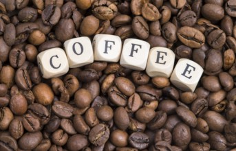 The photo shows roasted coffee beans with wooden letters