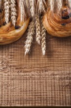 Ripe wheat ears rich raisin baked goods on oaken wooden board food and drink concept