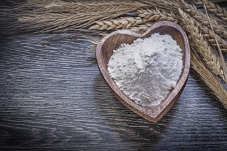 Composition of wooden bowl with flour golden rye wheat ears food and drink concept
