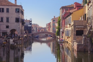 Bridge over canal in Chioggia, Italy. Typical Italian houses and gondolas, Chioggia, Italy, Europe