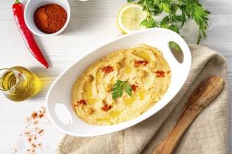Hummus paste with lemon and chilli on a white background