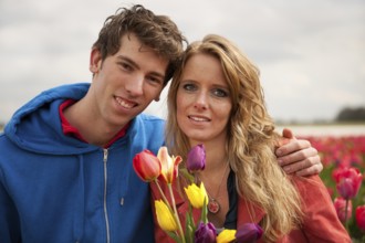 Young couple in Dutch flower fields with colorful tulips