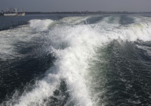 The engines of a powerful speedboat create a huge surf