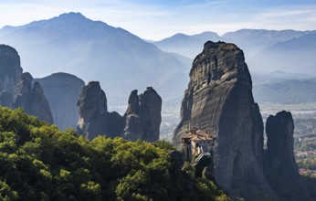 A landscape of the Meteora rock formations with the Saint Nikolaos monastery in the foreground