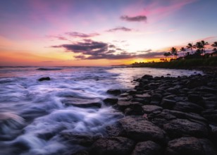 Sunset at a rocky beach with vivid warm colors and beautiful skies